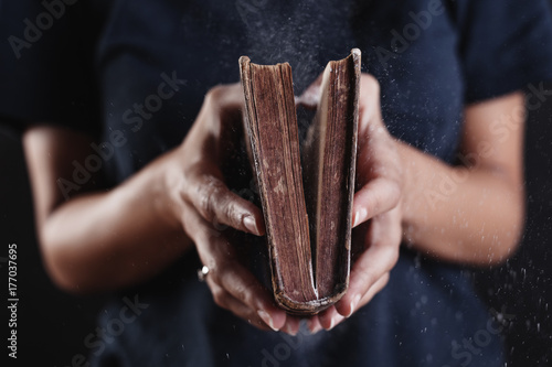 Hands of a woman opened a dusty old book. photo