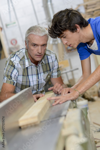 Carpenter and son using a table saw