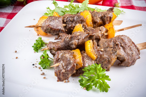 Lamb skewers on plate with vegetables