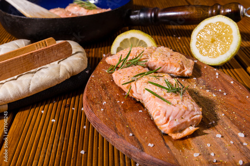 Salmon fillets. Grilled salmon, rosemary - herb decorationon on vintage pan or wooden board. roasted fish , wooden table. Studio shot. photo