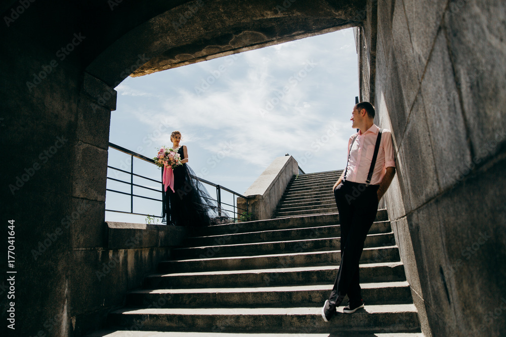 Bride and groom on the stairs near the river