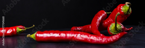 Chili.Red chili peppers on black slate board. Selective focus. Wide.