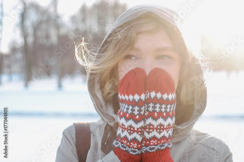 Woman hiding her face with her hands in mittens