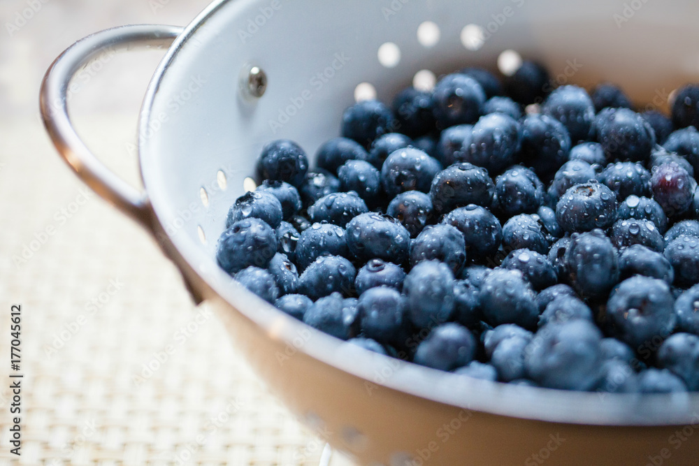 © Carolyn Lagattuta/Stocksy - Close up of a colander full of freshly washed blueberries