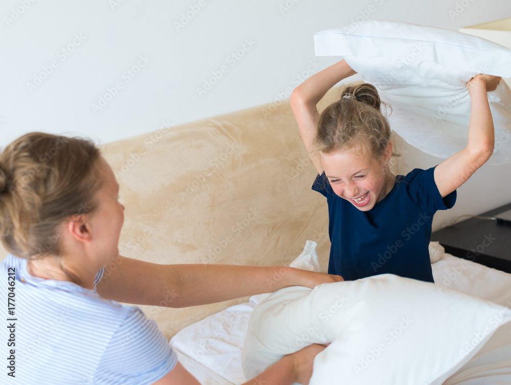 Mother and daughter fighting by pillows. Mother and daughter fighting by pillows.