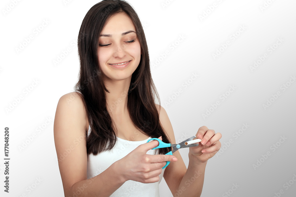 Portrait Of Beautiful Smiling Woman Holding Cigarette And Scissors In Hands. Quit Smoking Cigarettes Concept. High Resolution Portrait Of Beautiful Smiling Woman Holding Cigarette And Scissors In Hands. Quit Smoking Cigarettes Concept. High Resolution
