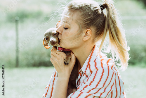 Woman playing with little dog outside