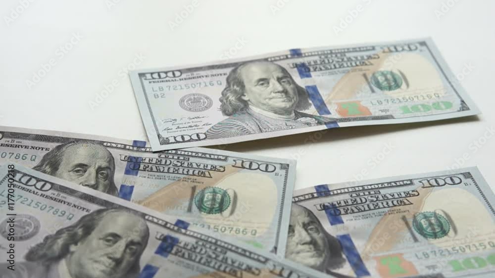 One hundred dollar bills falling on the white background One hundred dollar bills falling on the white background