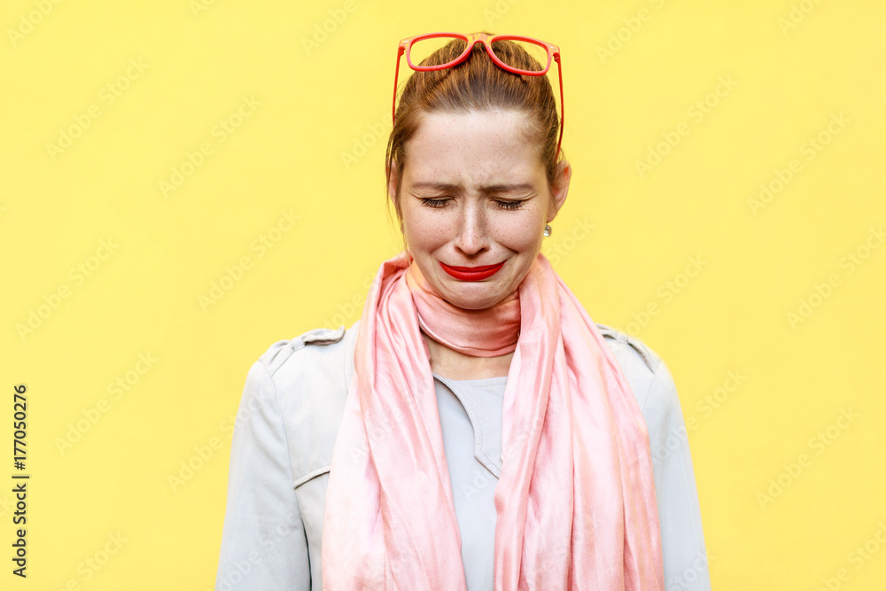 Portrait of unhappy and depressed young caucasian woman with ginger hair feeling ashamed or sick. Human face expressions and emotions concept.