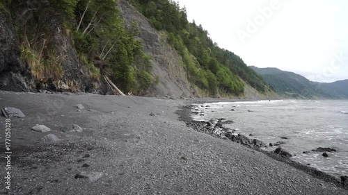 Stabilized walk ahead on rocky black sand beach of California's Lost Coast Trail. Shot in slow motion. photo