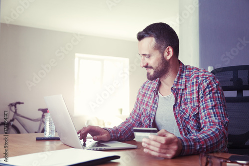 Man holding credit card and using laptop. Online shopping