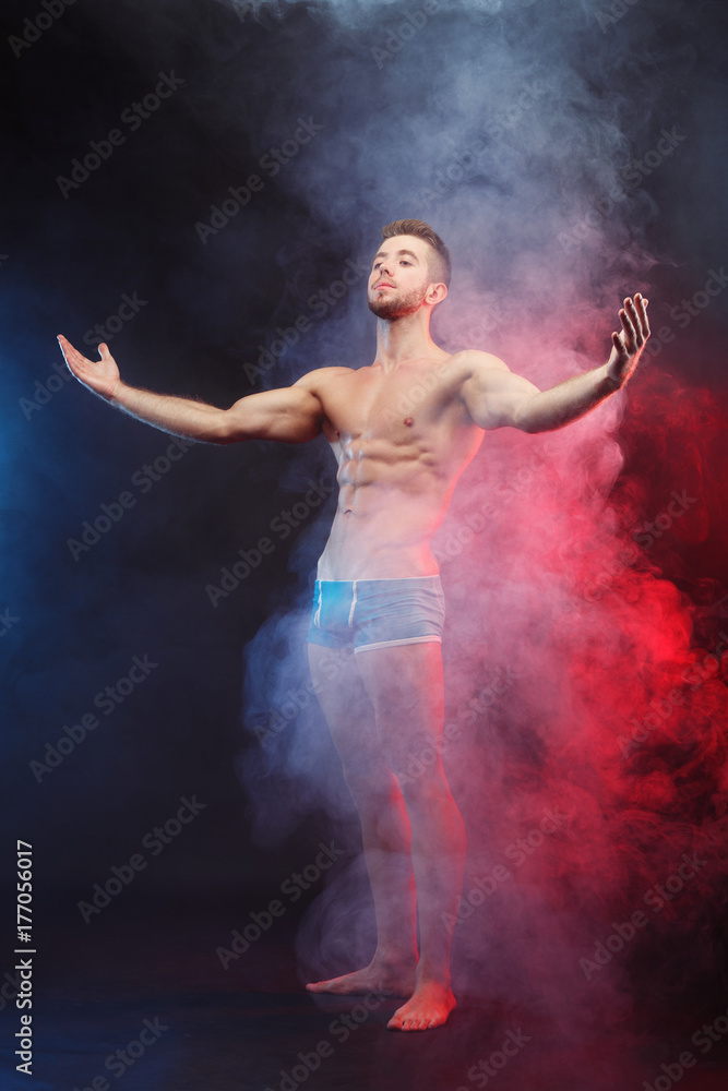 Power, strength, excellent body, bodybuilding, sports concept. Studio shoot of young handsome muscular fit handsome shirtless man with perfect six-pack abs and hands, vertical image