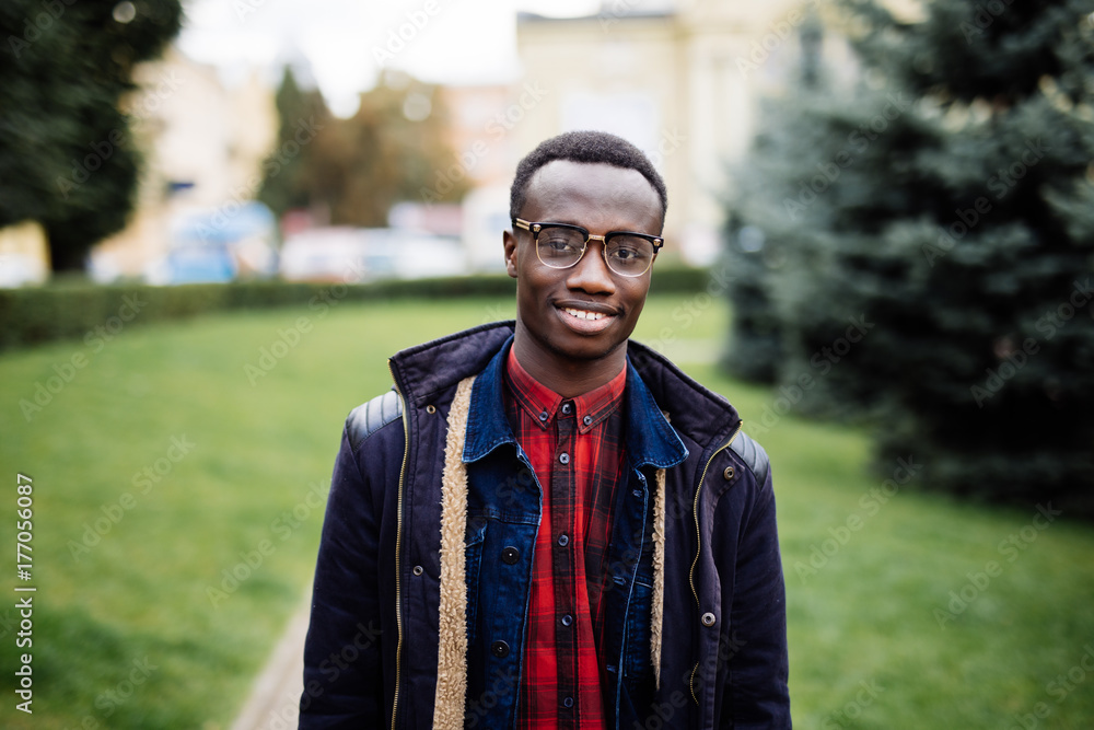 Portrait of handsome young man smiling outside with bag outdoors street
