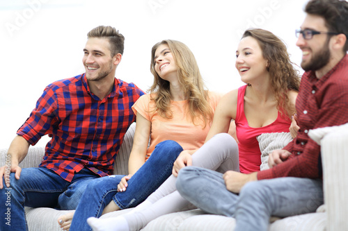 group of cheerful friends sitting on the couch