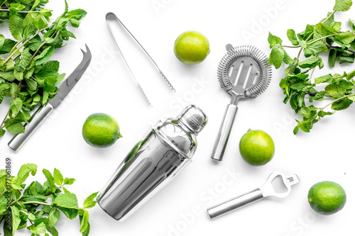 Make mojito cocktail with lime and peppermint in shaker. White background top view