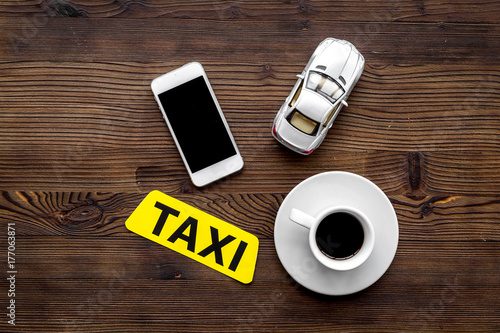 online order a taxi set with car toy, coffee and mobile on wooden background top view mock up