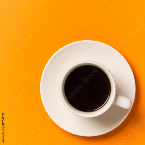 A cup of coffee isolated on orange . Top view.