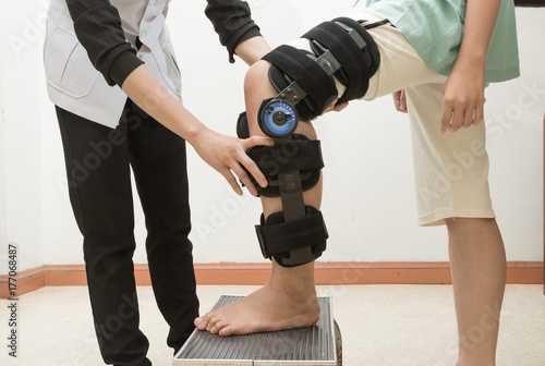 Therapist fitting a knee brace to patient leg