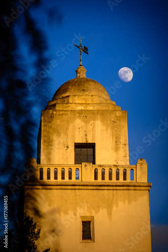 Φωτογραφία The moon rises near the Juniper Serra museum in San Diego, California