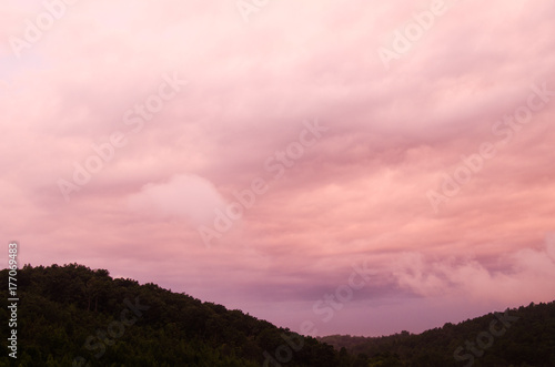 Pre-sunrise clouds take on unusual colors as the sun nears the horizon in the hills near Anniston, Alabama, USA