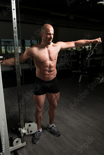 Bodybuilder Doing Heavy Exercise For Shoulders With Cable