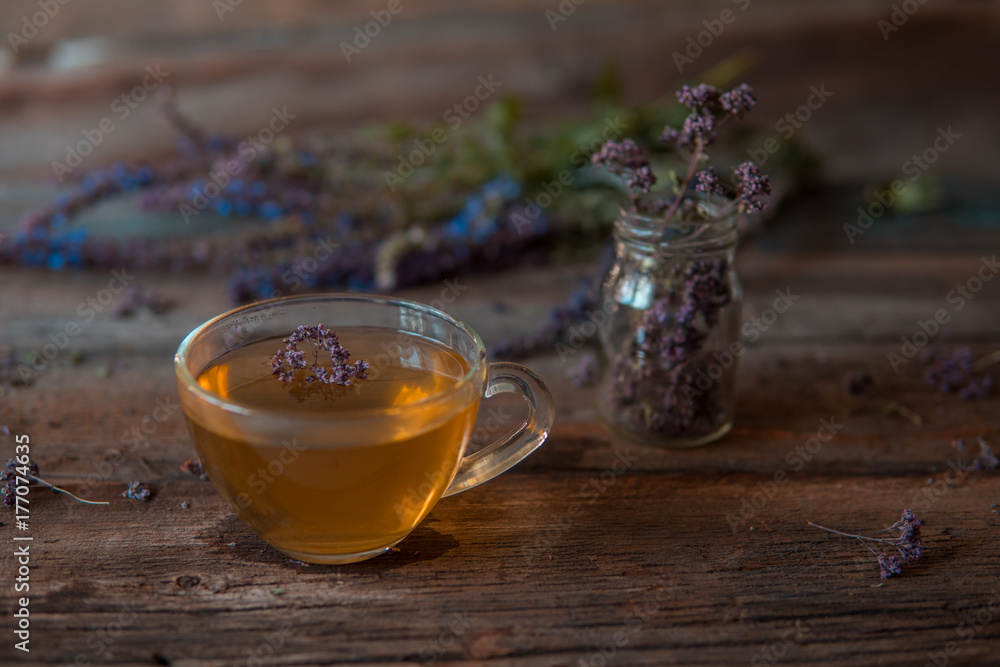 Fototapeta premium Green tea with herbals. Tea with oregano on the wooden background