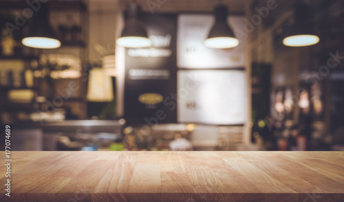 Wood table top on blurred of counter cafe shop with light bulb background.For montage product display or design key visual photo