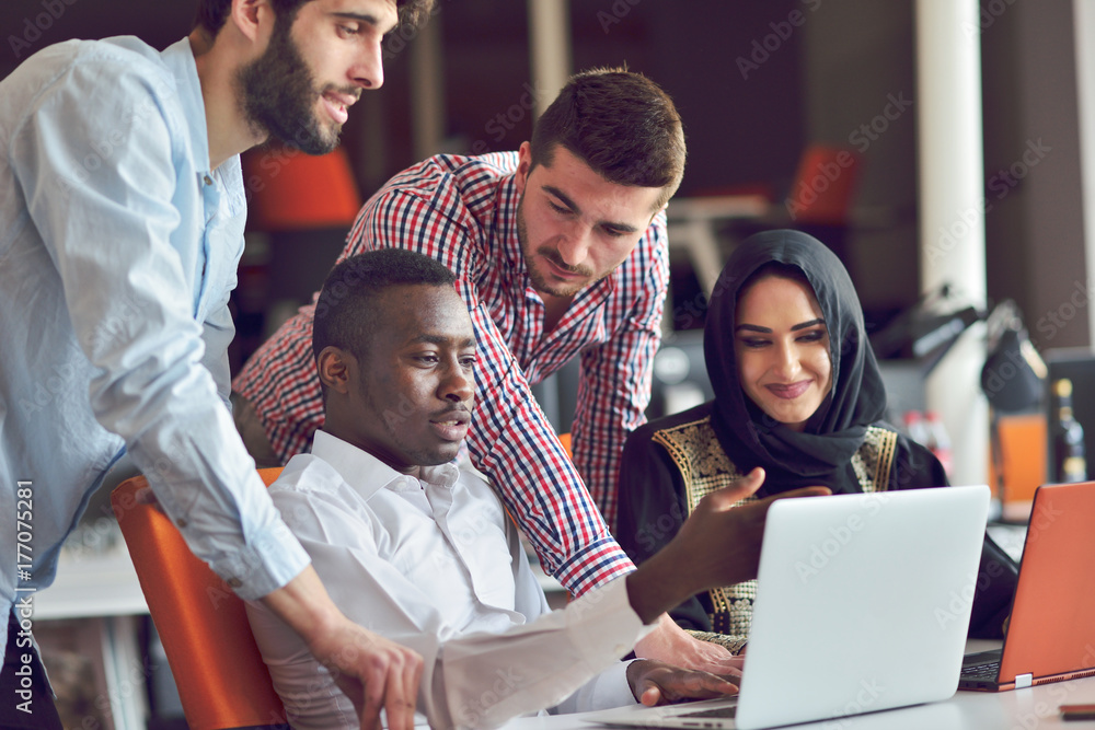 Obraz premium Multiracial contemporary business people working connected with technological devices like tablet and laptop