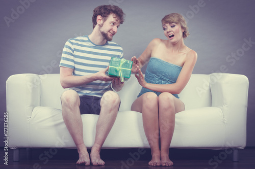 Young man giving offended woman gift box