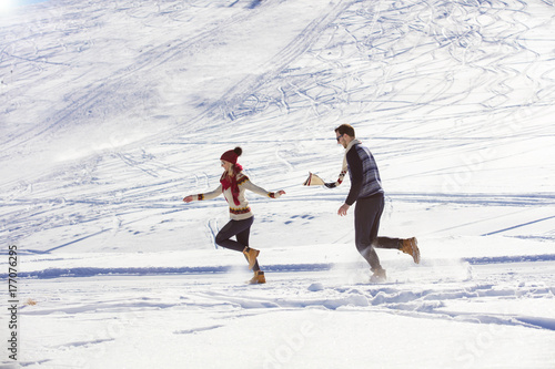 Carefree happy young couple having fun together in snow.