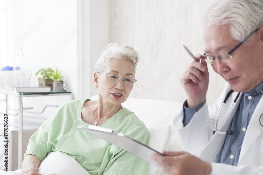 Obraz premium An old doctor is talking to an elderly patient while watching a medical record