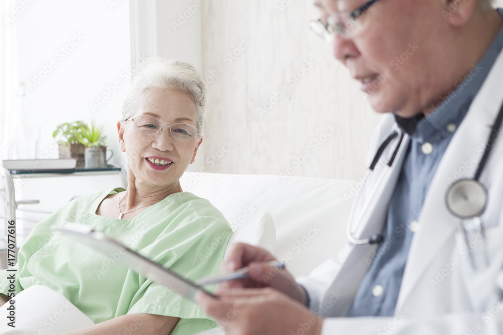 Obraz premium An old doctor is talking to an elderly patient while watching a medical record