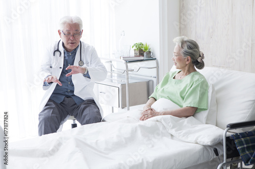 The elderly doctor speaking the postoperative course to the patient