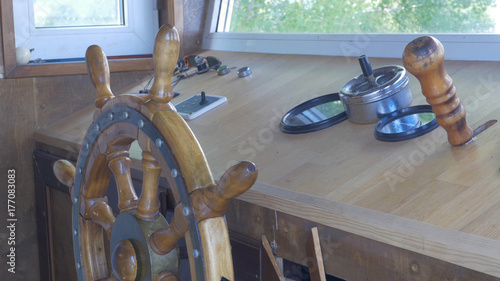 Close view into captain's cabins, navigation equipment and captain's hand on rudder during cruising. Captain's cabin of pleasure ship