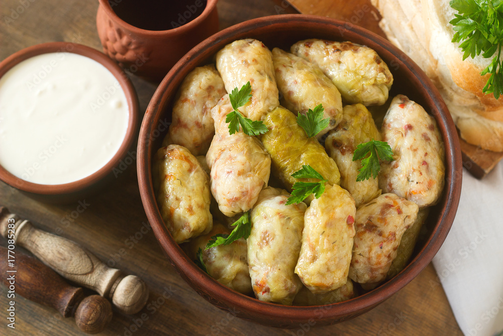 Cabbage rolls served with sour cream, bread and wine. Dolma, sarma, sarmale, golubtsy or golabki.