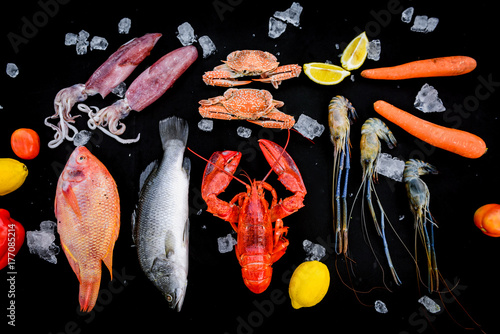BBQ ingredient; fish, squid, lobster, shrimp, vegetable and ice on black background