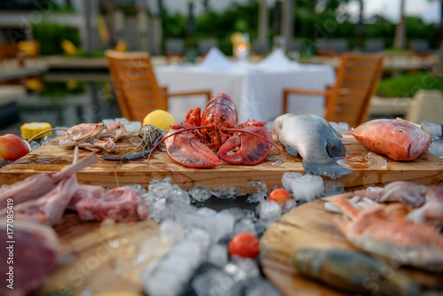 BBQ ingredient; fish, squid, lobster, shrimp, vegetable and ice and background of dining table