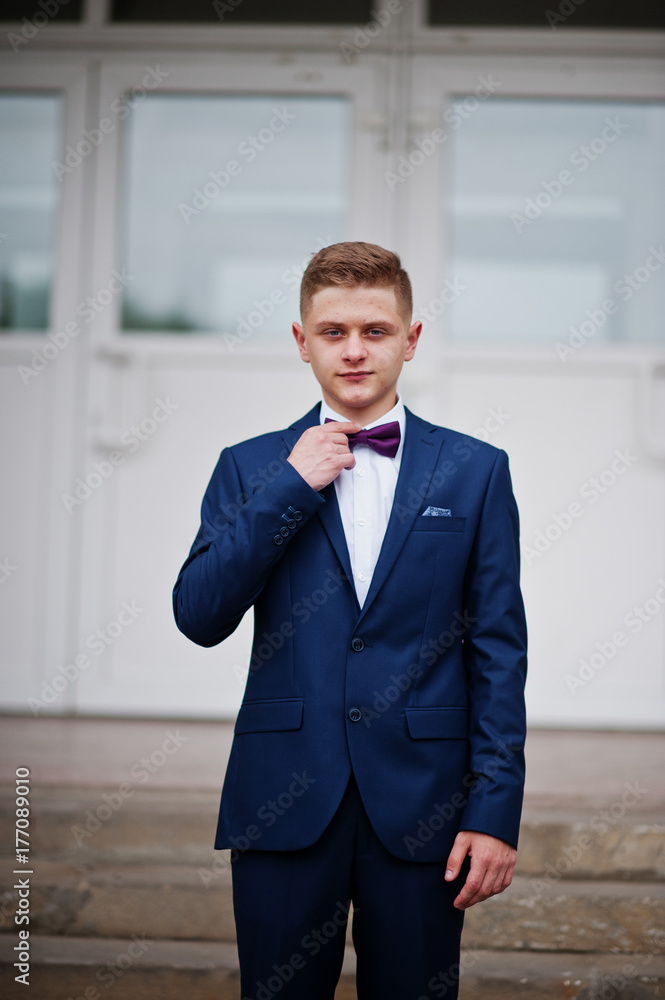 Portrait of a handsome high school graduate in stylish tuxedo posing on the stairs on the prom. Portrait of a handsome high school graduate in stylish tuxedo posing on the stairs on the prom.