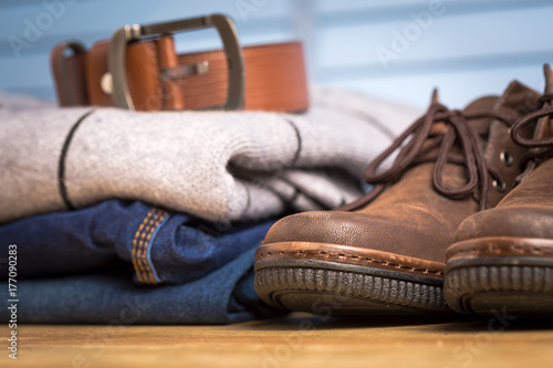 Men clothing asian style vintage with blue jeans pant and leather shoes in modern room with wooden table.