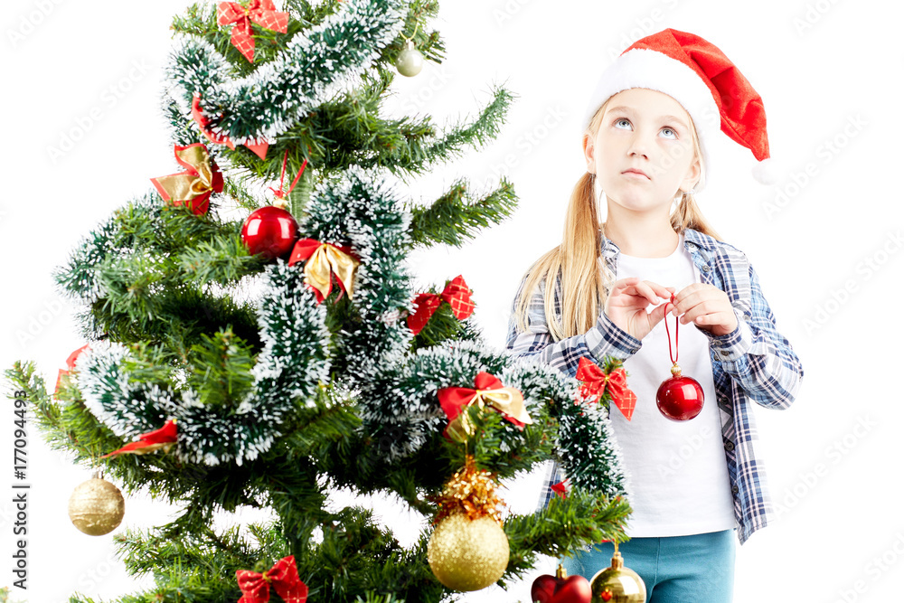 Studio portrait of little girl decorating Christmas tree