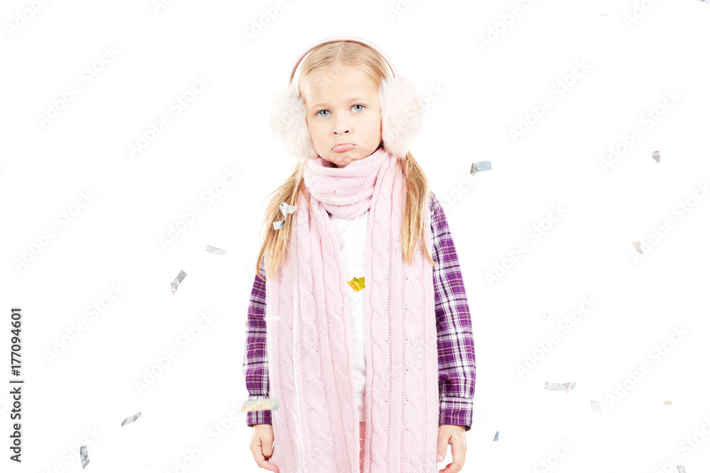 Portrait of little girl wearing scarf and winter ear muffs on white background