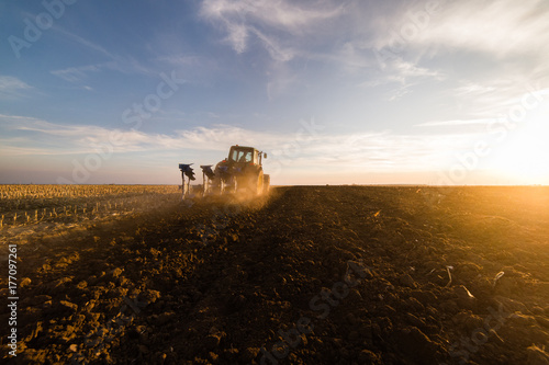 фотографія Tractor plowing fields  -preparing land for sowings