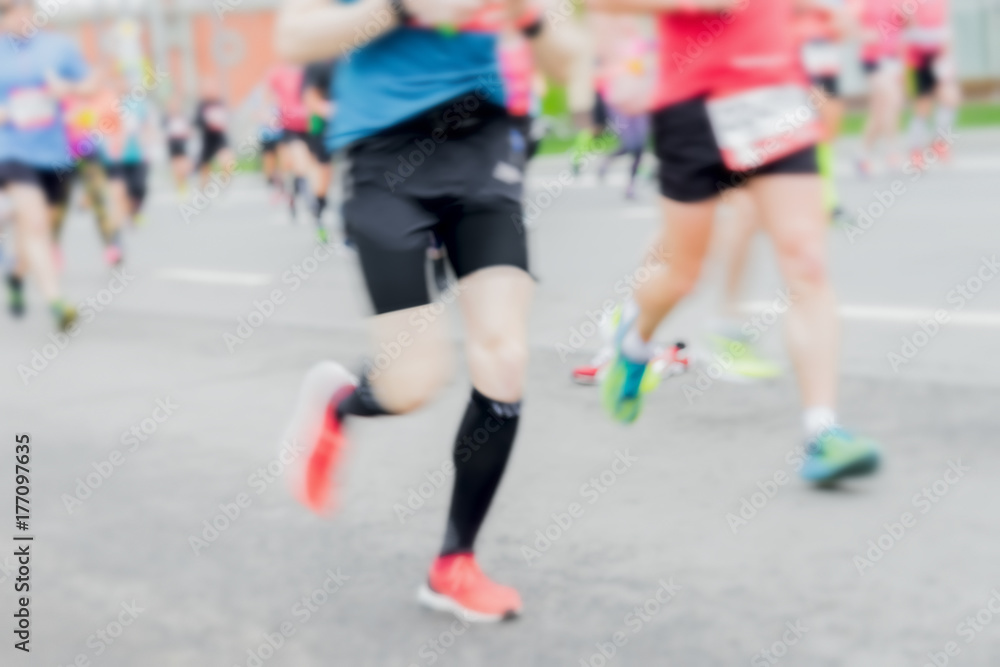 Close-up of feets, legs of runners, marathon on city streets. Abstract blurred sport background. Sport, fitness, healthy lifestyle