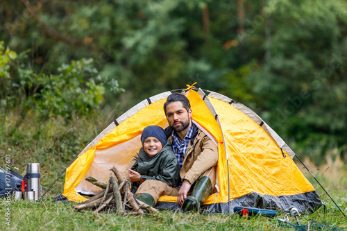 father and son sitting in tent