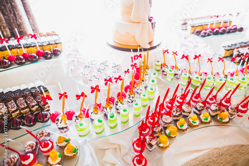Delicious sweets on wedding candy buffet with desserts, cupcakes