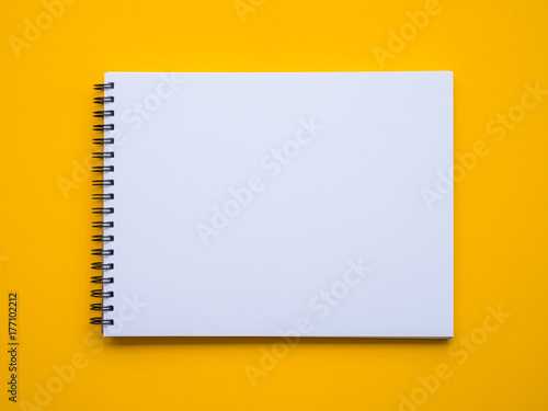 Notepad on yellow background photo