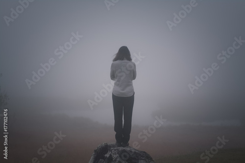 Depressive Frau steht an der Klippe und denkt an Selbstmord Depression Nebel Rückansicht