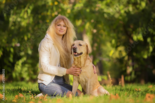 Nice long haired ukrainian girl with her favorite dog in the park