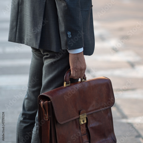 Cropped view of businessman holding briefcase outdoors