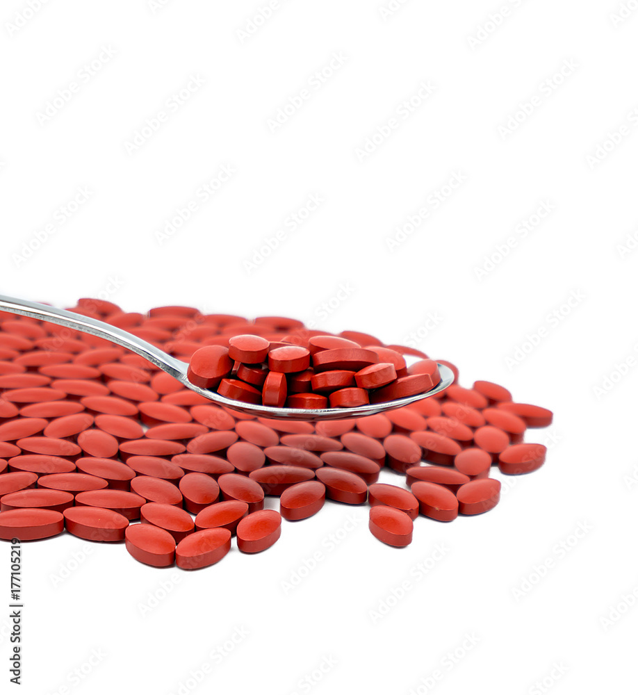 Iron tablets in spoon isolated on white background with copy space for text. Use for topics about treatment anemia in adult, elderly people and children. Blood donations concept. Iron tablets in spoon isolated on white background with copy space for text. Use for topics about treatment anemia in adult, elderly people and children. Blood donations concept.